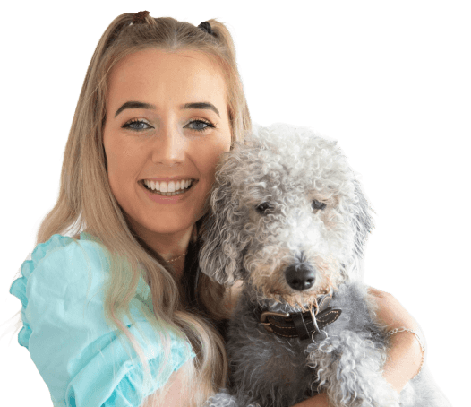 Smiling woman with long blonde hair holds a curly gray dog.